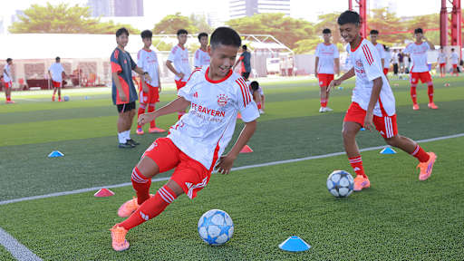 Ein junger Fußballspieler dribbelt um ein Hütchen beim Launch-Event mit CRC Sports als neuer Merchandising- und Vertriebspartner des FC Bayern in Thailand.