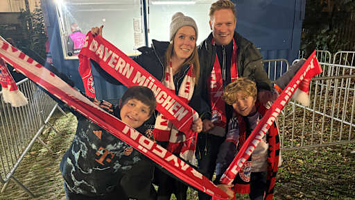 A family of FC Bayern fans holding their scarves