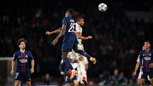 Michael Olise im Kopfballduell im Champions League-Spiel des FC Bayern bei Paris Saint-Germain