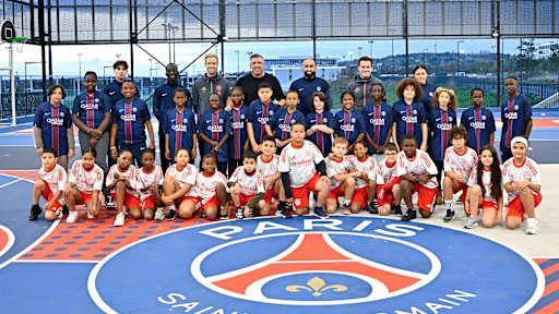 Jugendliche mit Trikots von PSG und FC Bayern gemeinsam mit den Coaches, darunter Roy Makaay, posieren für ein Foto