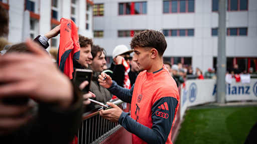 Tom Bischof unterschreibt ein Trikot eines Fans