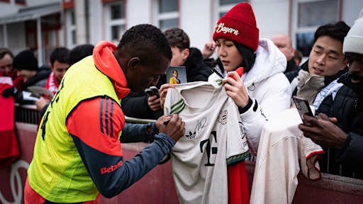 Nicolas Jackson unterschreibt ein Trikot einer Frau