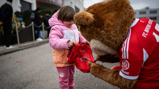 Berni unterschreibt auf einem Trikot von einem kleinen Mädchen