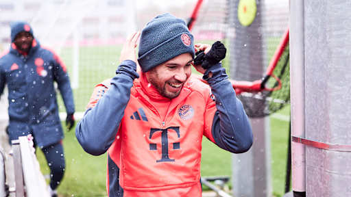 Raphael Guerreiro betritt den Platz lachend vor dem Abschlusstraining des FC Bayern vor dem Bundesliga-Spiel gegen Freiburg