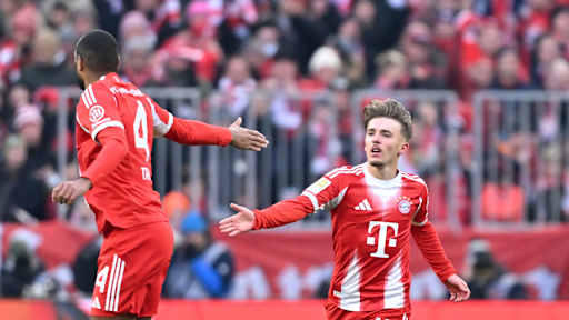 Lennart Karl schlägt ein mit Jonathan Tah im Bundesliga-Spiel des FC Bayern gegen den SC Freiburg.