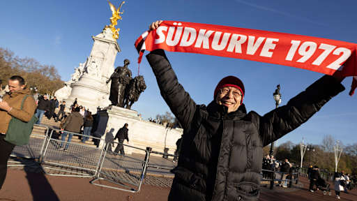 Ein FC Bayern Fan hält einen Schal mit Südkurve 1972 hoch