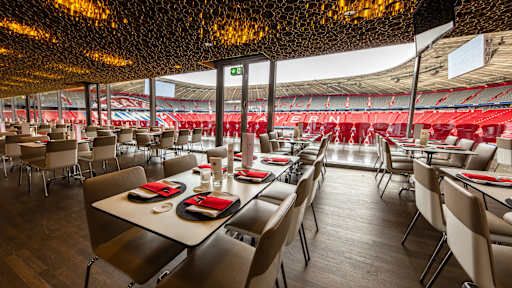 Business Club - niedrige Tisch vor Glasfront, mit Blick ins Stadioninnere