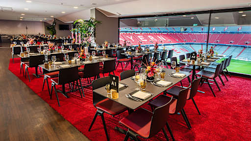 Eventbox - niedrige Tische vor Glasfront mit Blick ins Stadioninnere