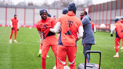 Alphonso Davies greift sich auf dem Rasen unter das Shirt im Training des FC Bayern