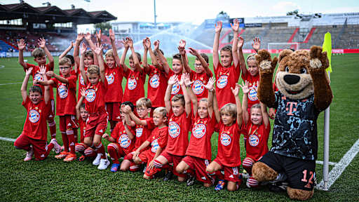 Einlaufkinder in roten Bayern-Shirts jubeln in Unterhaching mit Berni.