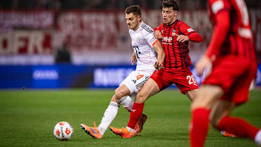 Josip Stanisic im ZWeikampf im Bundesliga-Spiel des FC Bayern in Heidenheim.