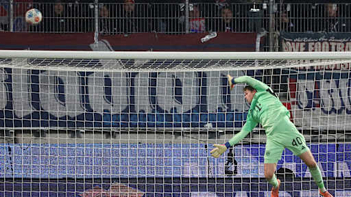 Jonas Urbig zeigt eine Parade im Bundesliga-Spiel des FC Bayern in Heidenheim.