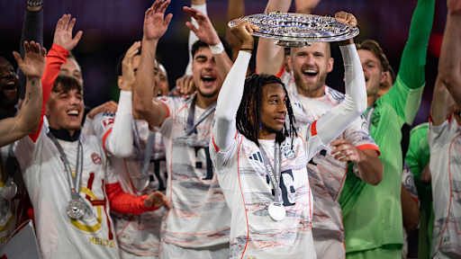 Michael Olise bejubelt den Gewinn der Deutschen Meisterschaft 2025 auf dem Rasen der Allianz Arena.
