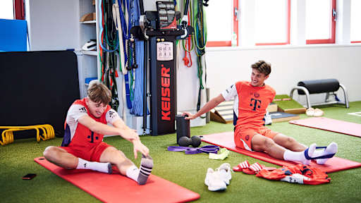 Lennart Karl und Tom Bischof bei Dehnübungen vor dem Trainingsstart des FC Bayern im Jahr 2026.