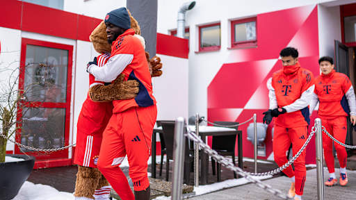 Dayot Upamecano umarmt Maskottchen Berni vor dem öffentlichen Training des FC Bayern vor Fans