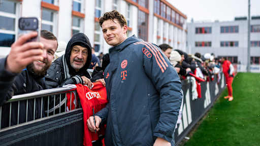 Jonas Urbig macht ein Selfie mit einem Fan im öffentlichen Training des FC Bayern vor Fans