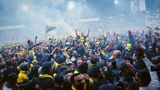 Franjo Ivanovic celebrates with fans after Union Saint-Gilloise win the title.
