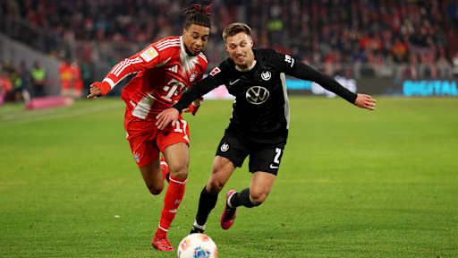 Michael Olise im Laufduell mit Kilian Fischer im Bundesliga-Spiel des FC Bayern gegen den VfL Wolfsburg