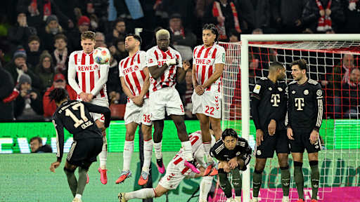 Michael Olise schießt einen Freistoß über die Mauer im im Bundesliga-Spiel des FC Bayern beim 1. FC Köln