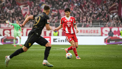 Minjae Kim mit Ball am Fuß während des Heimspiels des FC Bayern in der Bundesliga gegen den FC Augsburg