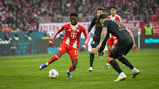 Alphonso Davies mit Ball am Fuß während des Heimspiels des FC Bayern in der Bundesliga gegen den FC Augsburg