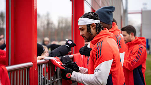 Serge Gnabry unterschreibt ein Trikot von einem Fan