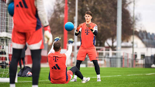 Sven Ulreich wirft im Sitzen einen Medizinball zu Jannis Bärtel im Training des FC Bayern