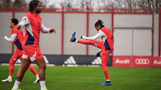 Michael Olise streckt das rechte Bein beim Warmlaufen nach oben im Abschlusstraining des FC Bayern vor dem Pokalviertelfinale gegen RB Leipzig