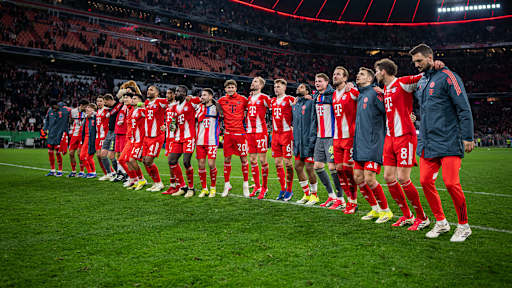 Spieler des FC Bayern hüpfen Arm in Arm vor der Südkurve nach dem Sieg gegen Leipzig.