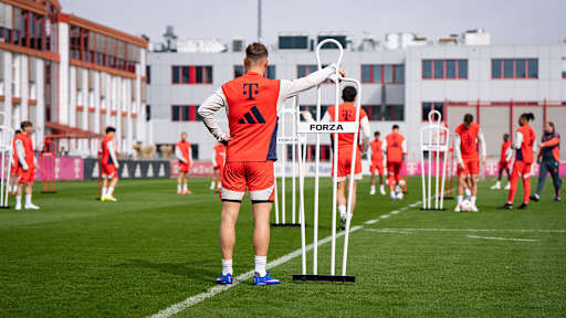 Joshua Kimmich steht neben eine Stange und beobachtet das Geschehen im Training des FC Bayern