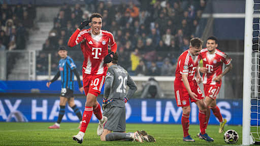 Jamal Musiala jubelt und zeigt auf seinen Kopf nach dem 6:0 im Hinspiel des FC Bayern bei Atalanta Bergamo im Champions League Achtelfinale