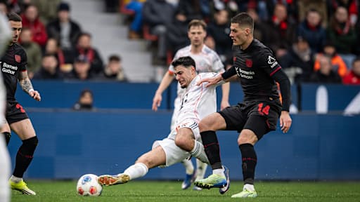 Aleksandar Pavlovic grätscht den Ball gegen Patrik Schick im Bundesliga-Spiel des FC Bayern bei Bayer 04 Leverkusen