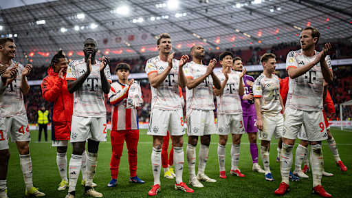 Spieler des FC Bayern feiern nach dem 1:1 in Leverkusen vor der Fankurve