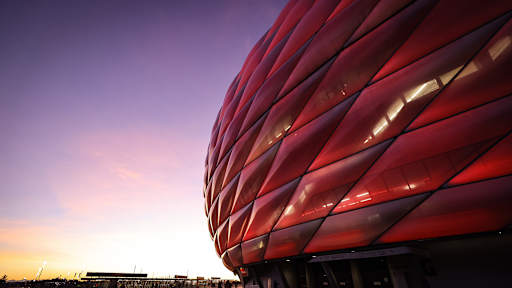 Rote Fassade der Allianz Arena im Abendhimmel