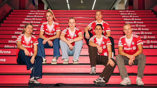 Die FC Bayern Frauen sitzend in der Allianz Arena.