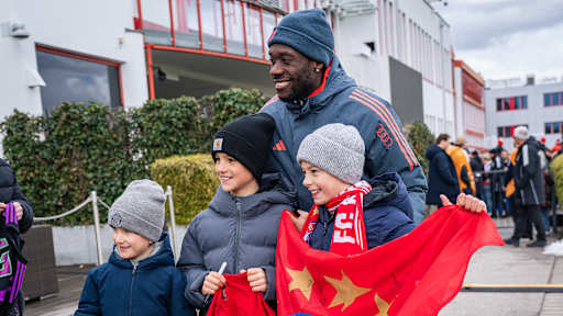 Alphonso Davies macht ein Foto mit drei Kindern