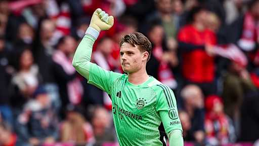 Jonas Urbig streckt die Faust in die Luft während des Bundesliga-Heimspiels des FC Bayern gegen den VfB Stuttgart