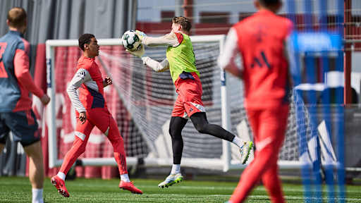 Jonas Urbig fängt einen Ball gegen Jamal Musiala ab