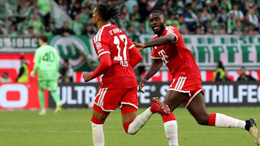 Michael Olise jubelt mit Dayot Upamecano im Bundesliga-Spiel des FC Bayern beim VfL Wolfsburg