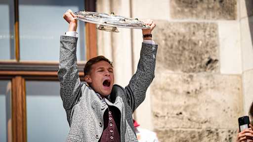 Joshua Kimmich jubelt mit der Meisterschale auf dem Rathausbalkon am Münchner Marienplatz