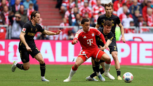 Jamal Musiala im Kampf um den Ball mit Eric Martel im Bundesliga-Spiel des FC Bayern gegen den 1. FC Köln