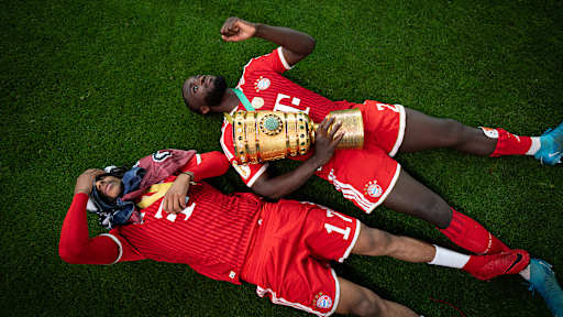 Michael Olise und Dayot Upamecano jubeln nach dem Triumph des FC Bayern im DFB-Pokal-Finale gegen den VfB Stuttgart.