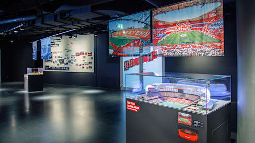 Ausstellungsbereich für die Allianz Arena im FC Bayern useum mit Bildern und einem Modell des Stadions