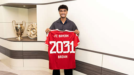 Nathaniel Brown hält ein FCB-Trikot mit 2031 Brown