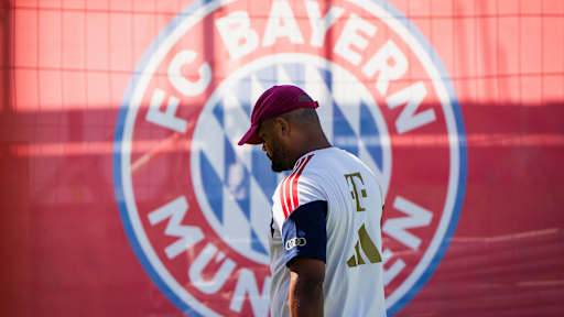 Trainer Vincent Kompany vor einem großen Bayern-Logo im Training des FC Bayern