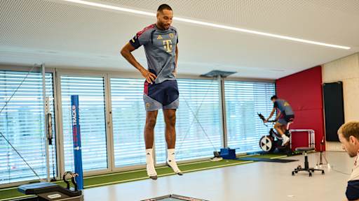 Jonathan Tah springt  im FC Bayern Trainingsoutfit