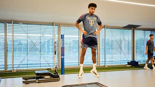 Nathaniel Brown springt  im FC Bayern Trainingsshirt