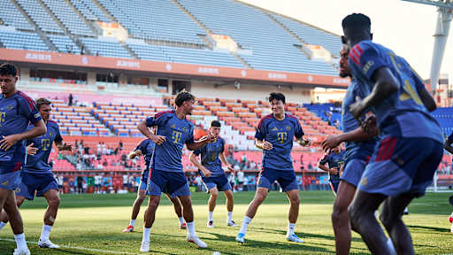 Tom Bischof und Minjae Kim lachend beim Warm up im öffentlichen Training des FC Bayern im Jeju World Cup Stadium