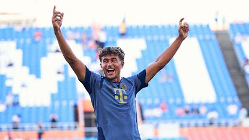 Tom Bischof jubelt mit erhobenen Armen im öffentlichen Training des FC Bayern im Jeju World Cup Stadium