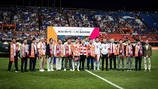 Offizielle des FC Bayern sowie aus Südkorea nehmen Aufstellung auf dem Rasen vor Anpfiff des Spiels Jeju SK vs. FC Bayern